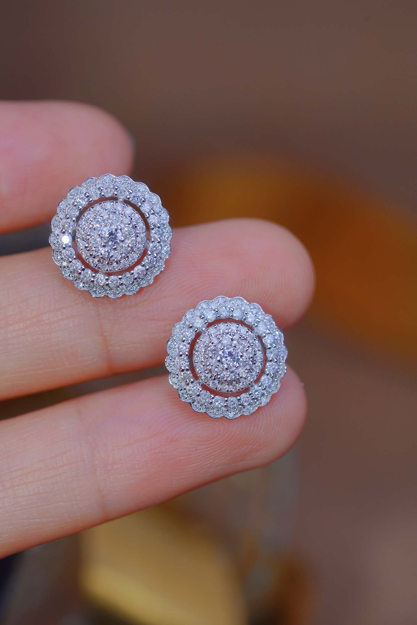 18k gold earrings set with a 1.00-carat natural diamond in a cluster setting.