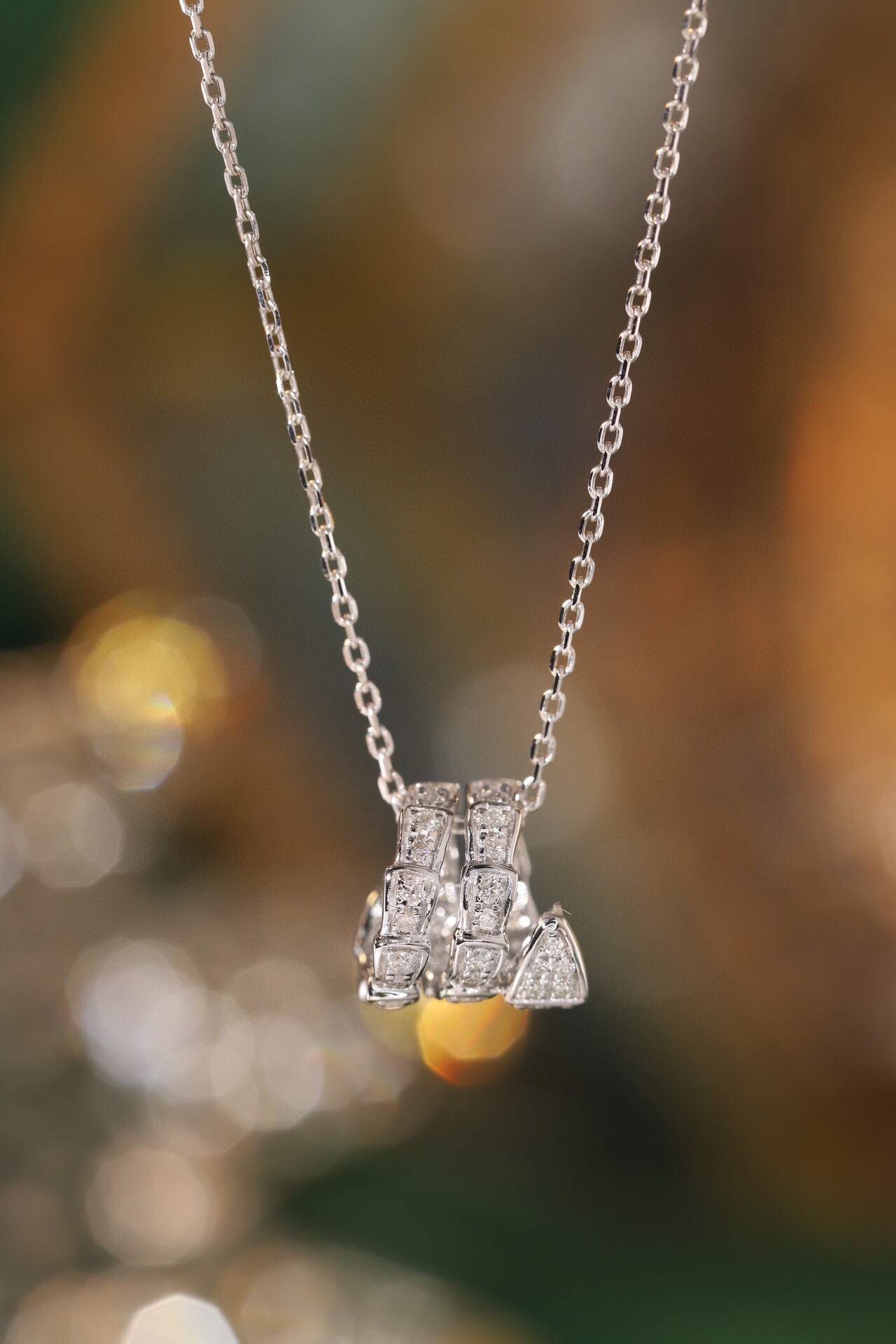 18k gold pendant in snake design, set with a 0.25ct diamond (chain not included)