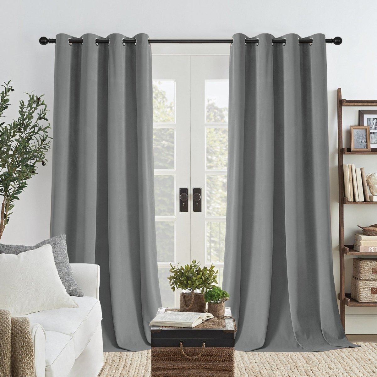 Two royal blue velvet blackout curtains with grommets on double doors, providing thermal insulation and privacy.