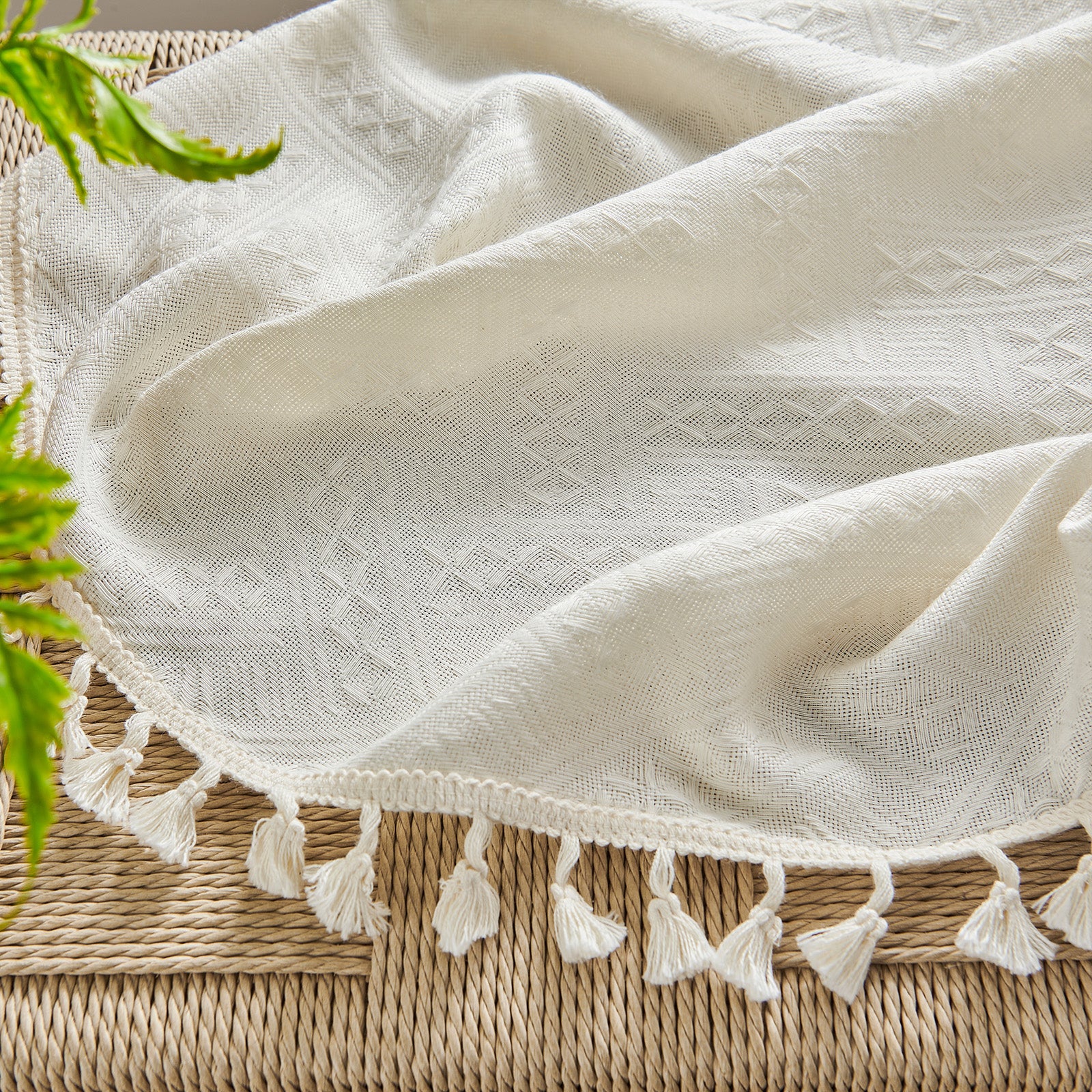 Close up of Joydeco beige boho curtains, showing basketweave texture and cream tassels on hem for light filtering.