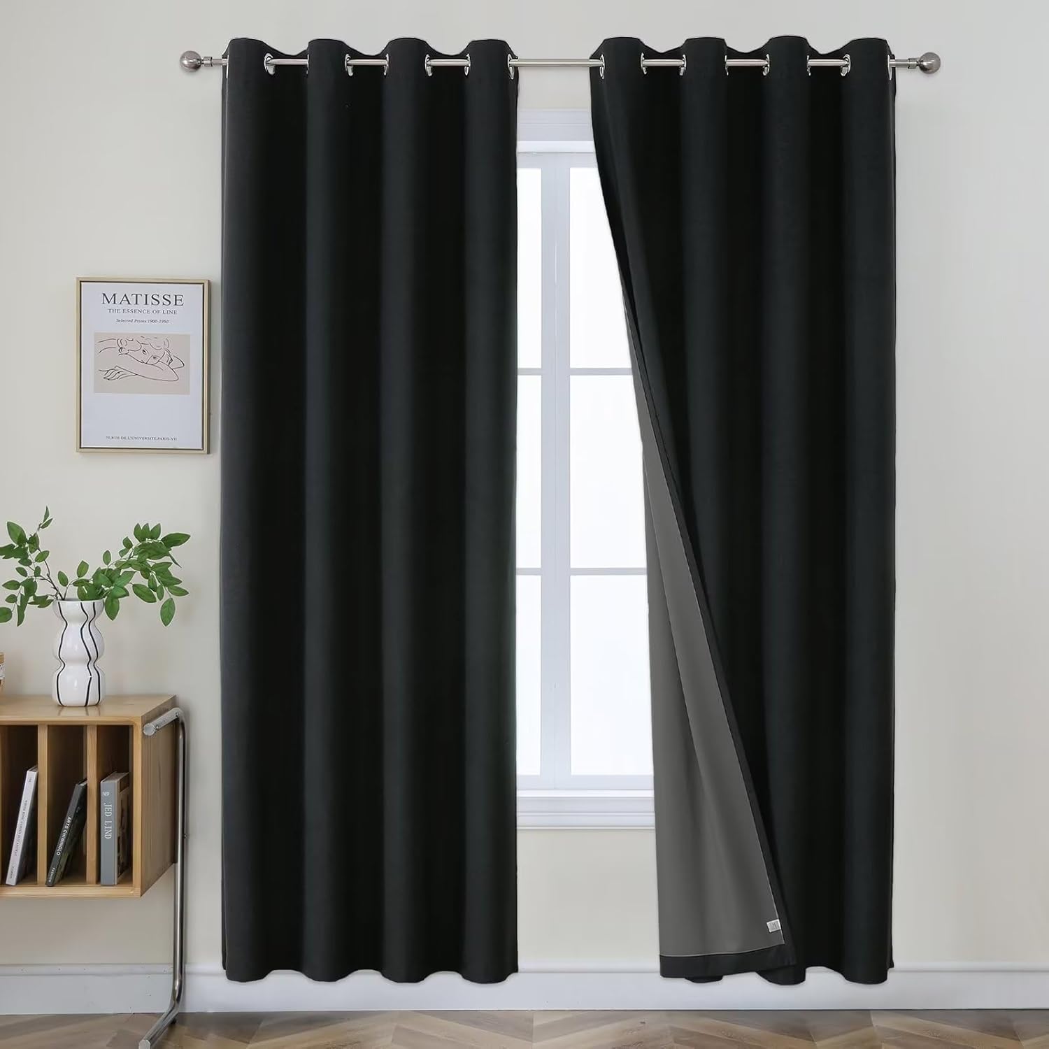 Black faux linen blackout curtains with grey lining visible through partially open panel, grommets.