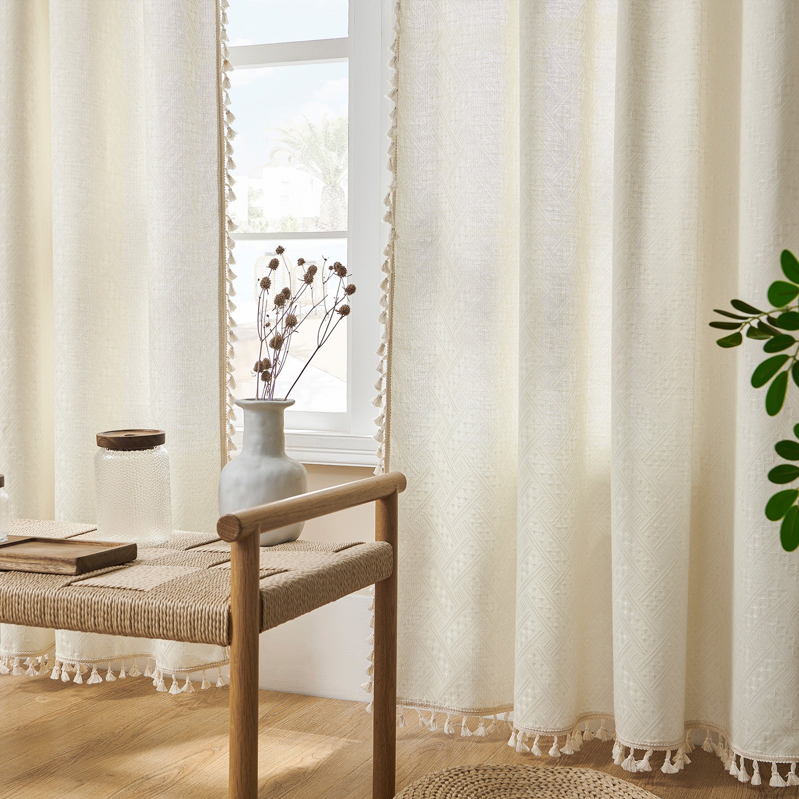 Beige boho curtains with basket weave pattern and tassel trim, semi-sheer fabric filtering light in a bedroom.