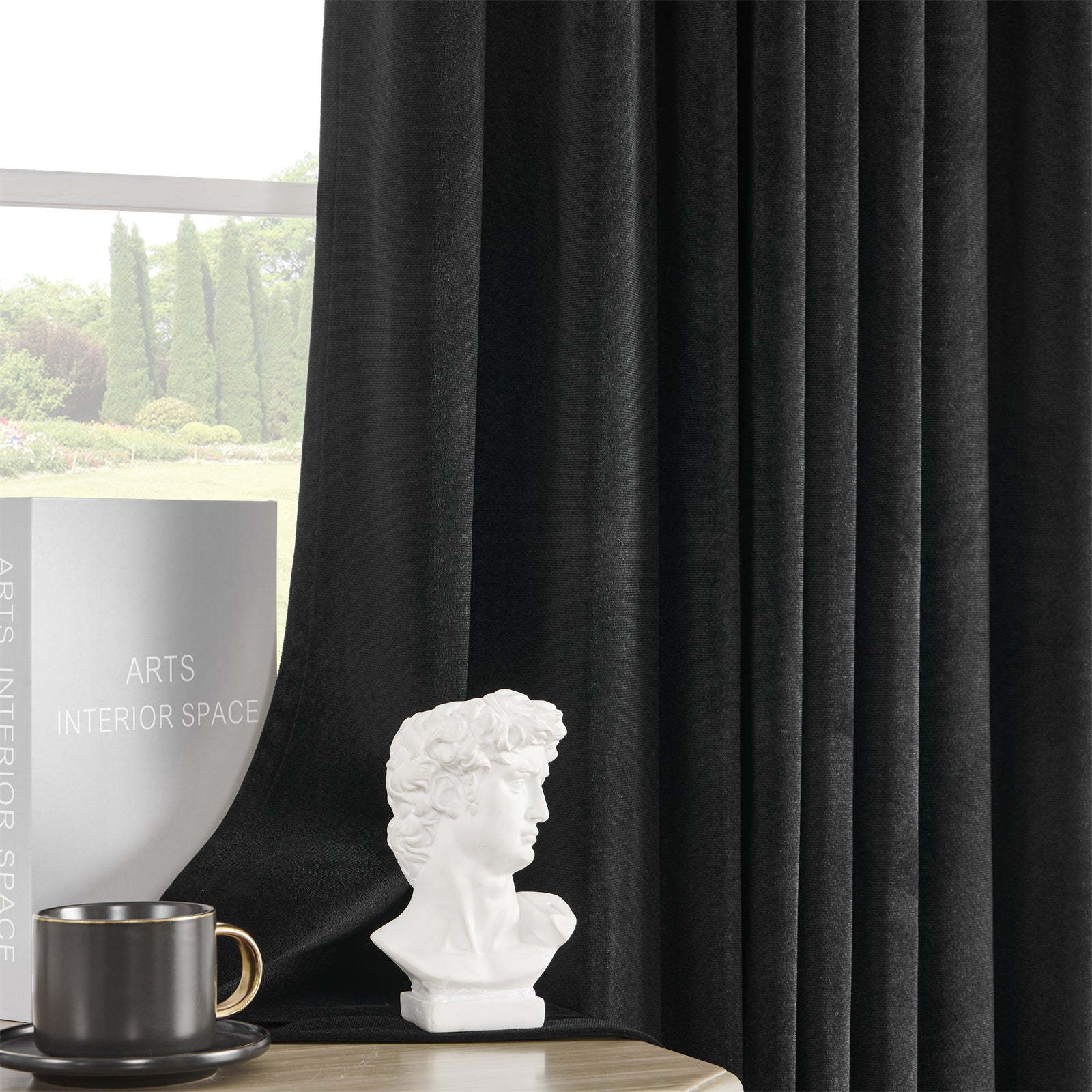 Joydeco black velvet blackout curtains, 84 inch length, plush texture, luxury sheen, in a styled room with decor.