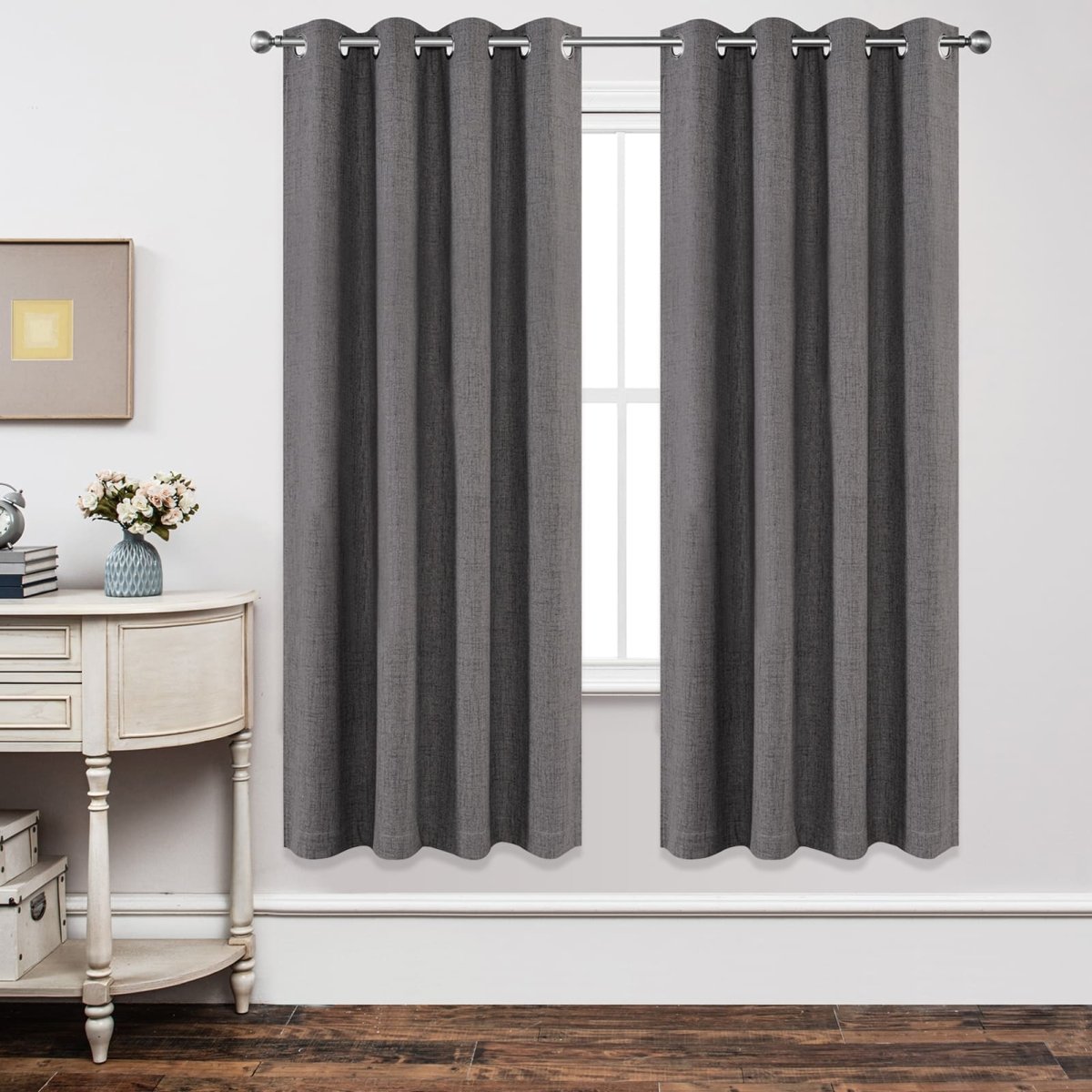 Two grey textured linen blend blackout curtains with grommets, blocking light from a window on a product page.