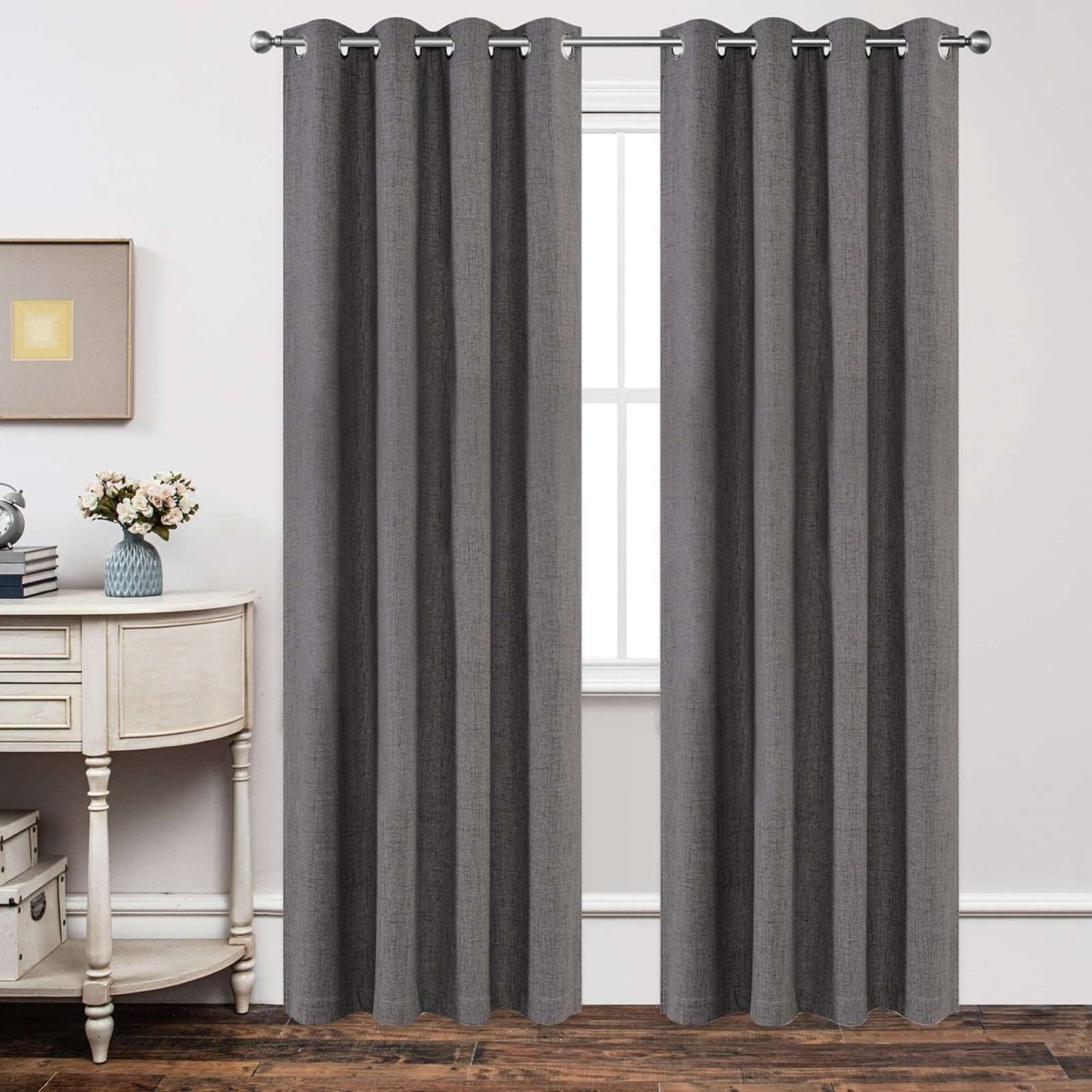 Two dark grey linen blend blackout curtains with textured weave hang on a silver rod, providing room decor and privacy.