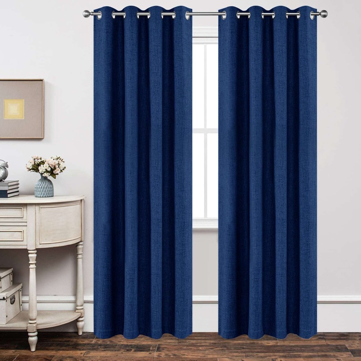 Navy blue linen blackout curtains with textured weave and grommet tops hanging on a silver rod.