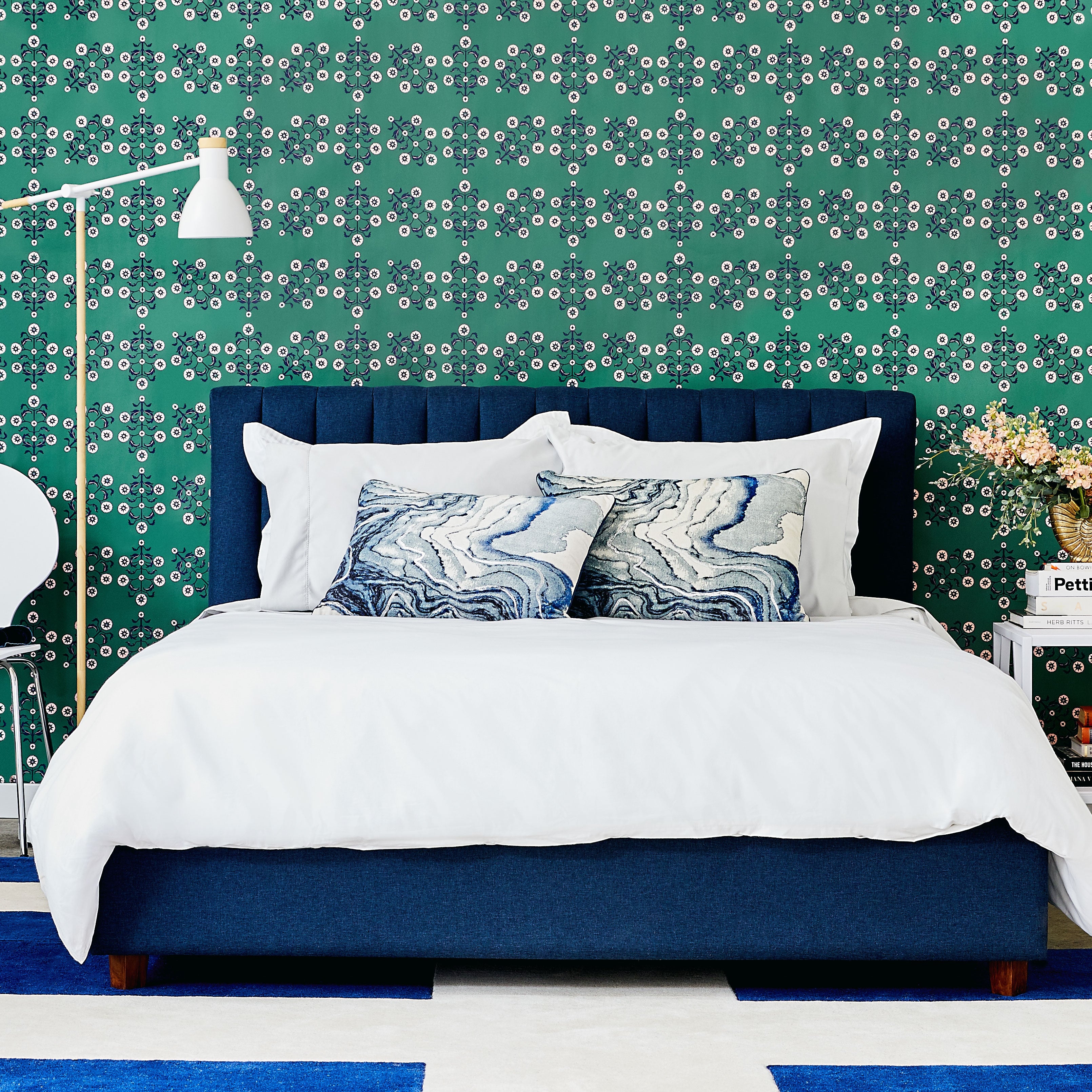Block Print Floral WALLPAPER in green displayed in a bedroom.