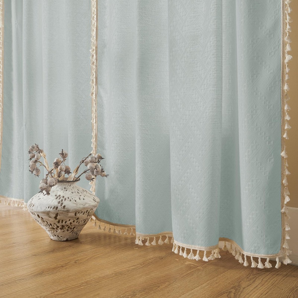 Joydeco ice blue linen curtains with cream tassels and subtle geometric pattern, farmhouse boho style, light filtering.