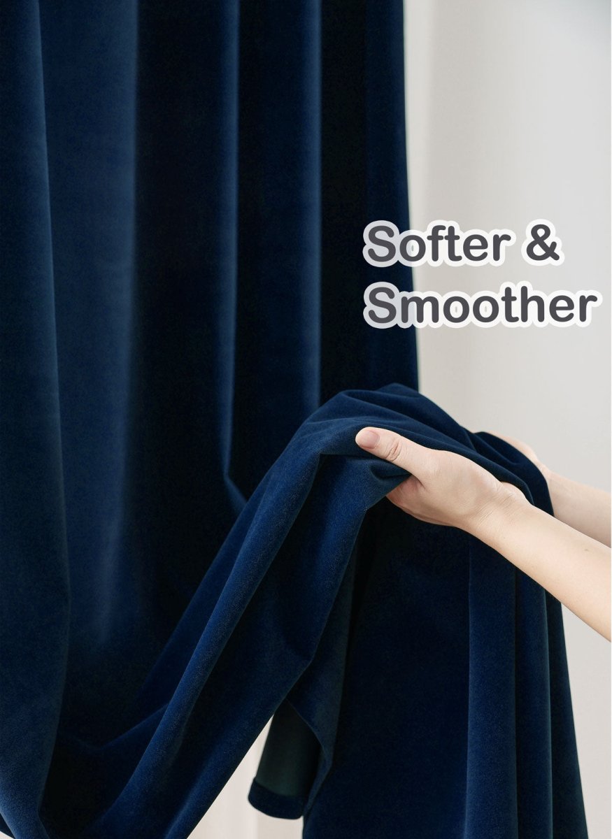 Close-up of navy velvet curtains with hands showing soft texture, highlighting quality.