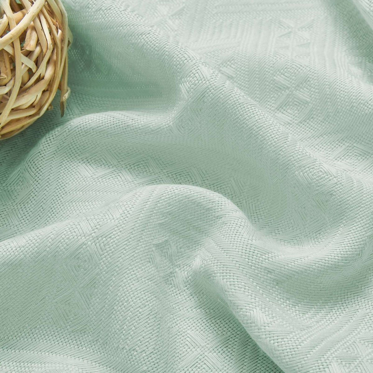 Close-up of mint green boho linen sheer curtain fabric with diamond weave texture, showcasing product detail and color.