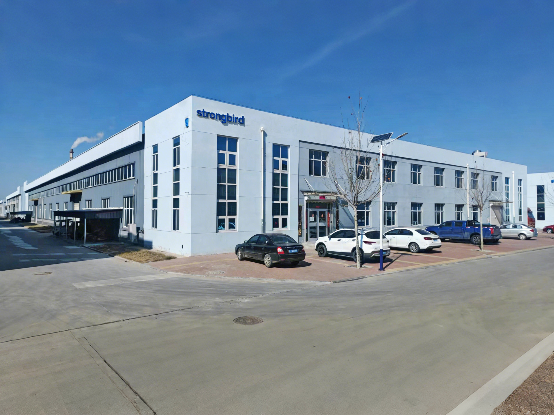 {"default":"Strongbird factory production line showing workers assembling folding luggage carts and shopping trolleys on a manufacturing assembly line."}
