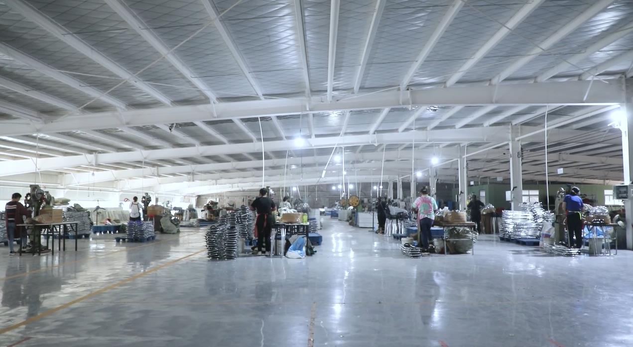 {"default":"Factory workers operate machinery and assemble products on a production line inside an industrial manufacturing facility."}
