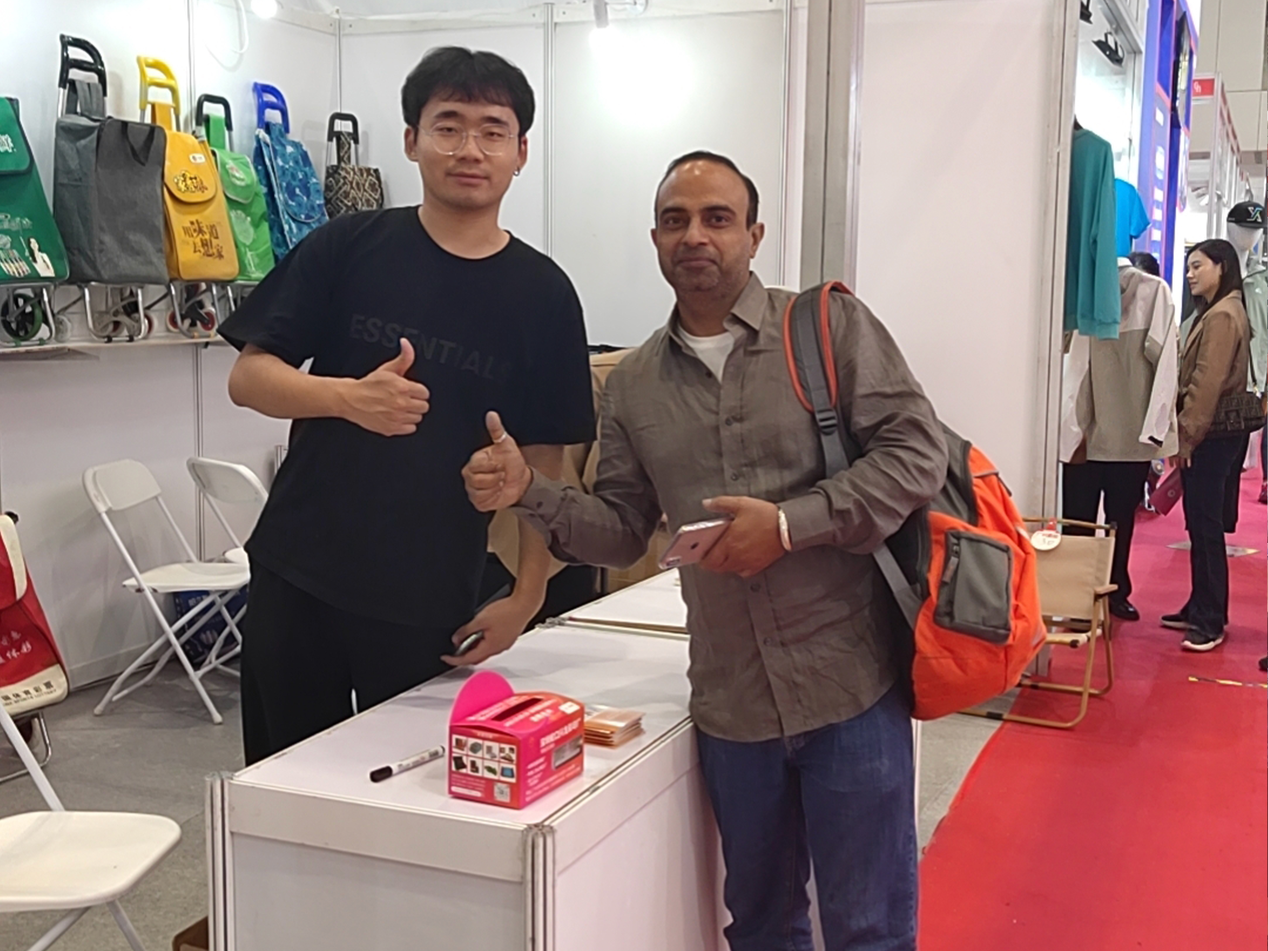 {"default":"International visitors posing for a group photo with Chinese factory staff at a manufacturing facility in China, all smiling warmly"}
