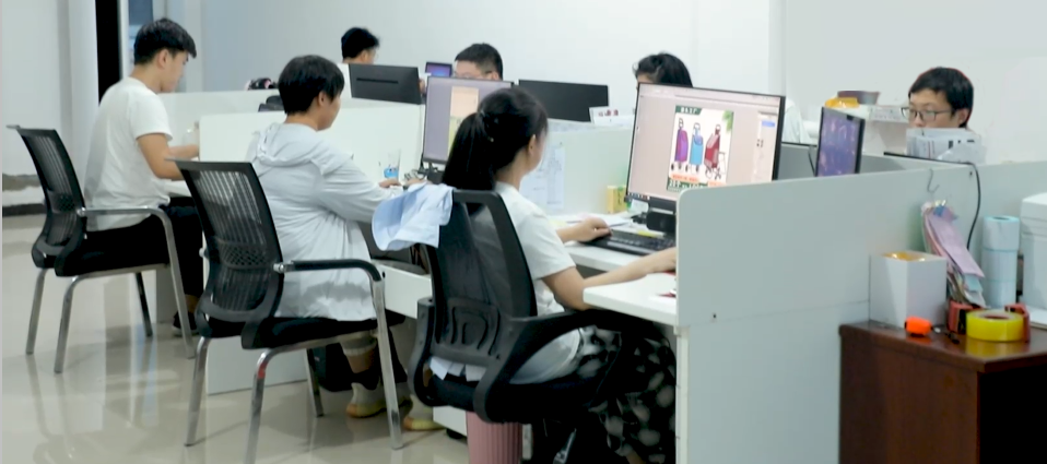 {"default":"Office workspace with employees working at computers, designing and developing products in a collaborative environment"}
