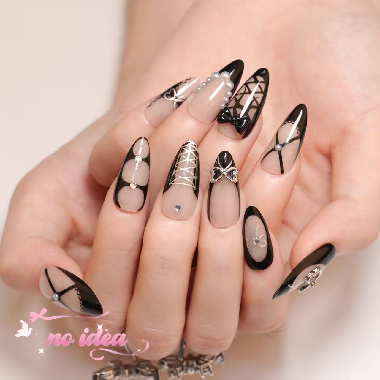 Nails Design in black metallic with a large, reflective 3D silver bow on the ring finger, displayed with glue and tools.