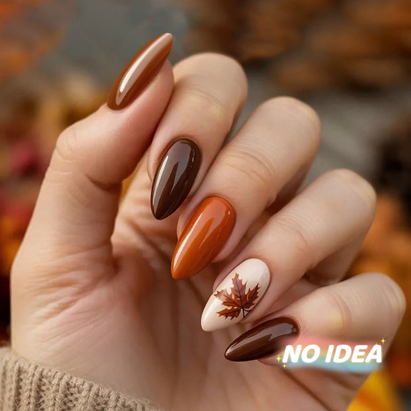 Almond shaped press on nails in a warm gradient of autumn orange and brown colors.