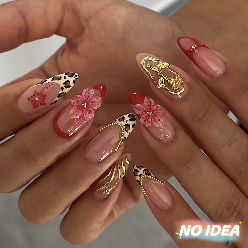 Almond shaped nails with a nude French tip, leopard print, and small floral details.