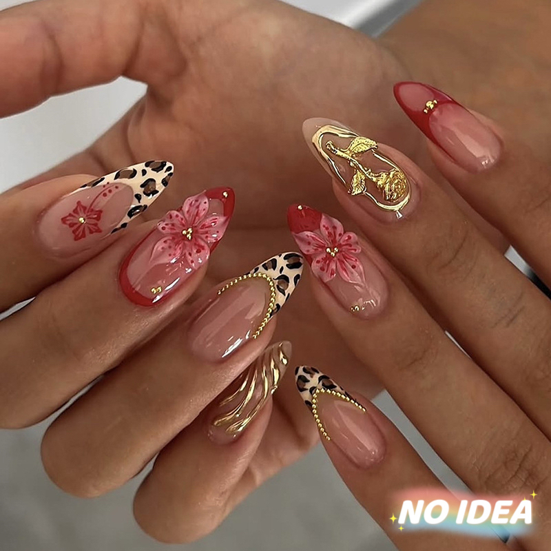 Almond shaped nails with a nude French tip, leopard print, and small floral details.