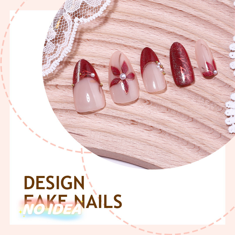 Set of short almond shaped press on nails in wine red with metallic silver floral designs, arrayed by size.