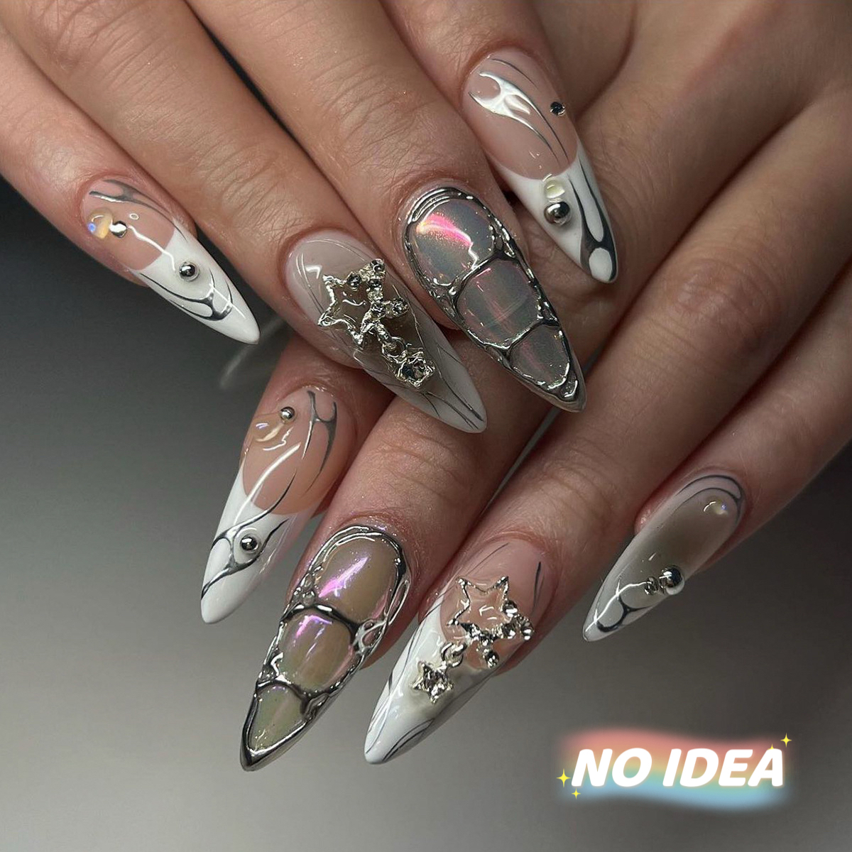 Long almond shaped nails in grey metallic with silver star charms and clear rhinestones.