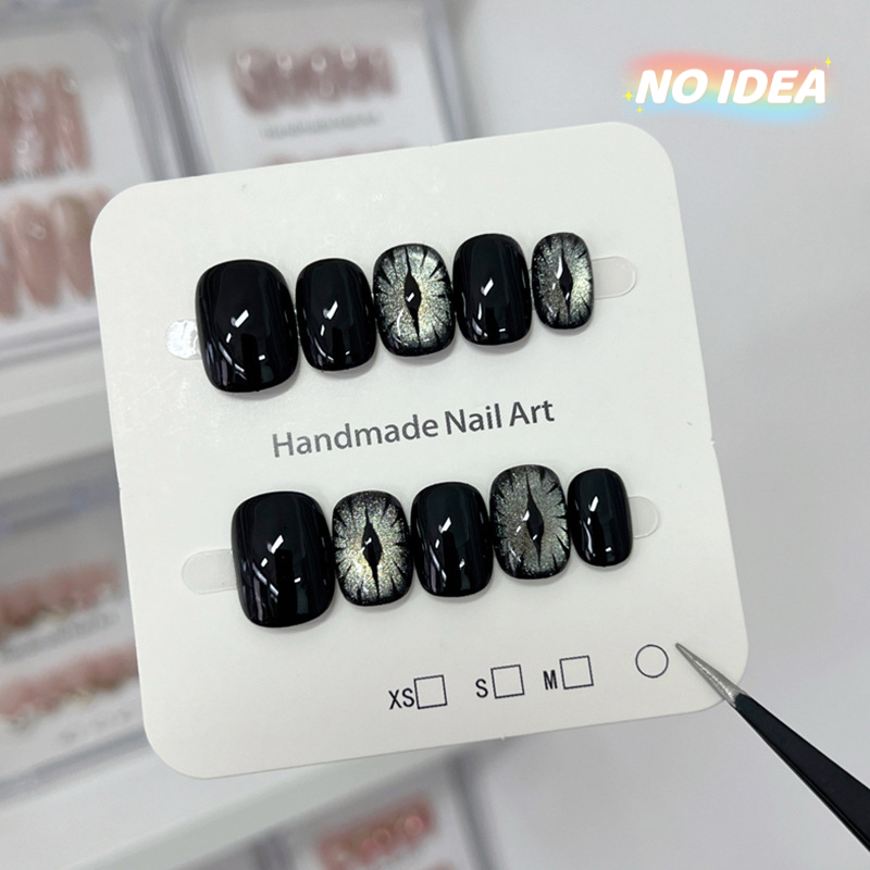 Short black cat eye effect press on nails with a magnetic shimmer, shown in a set of 10.