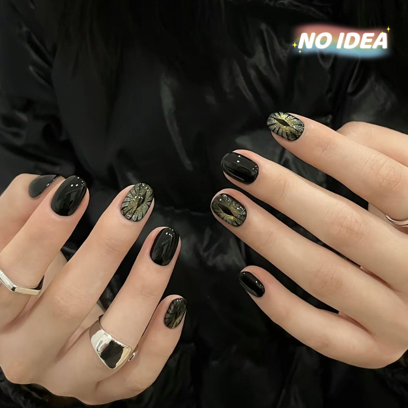 Short black cat eye effect press on nails with a magnetic shimmer, shown in a set of 10.