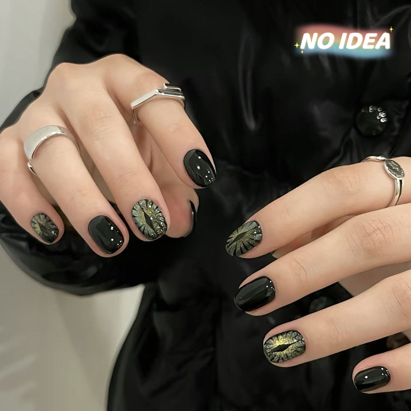 Short black cat eye effect press on nails with a magnetic shimmer, shown in a set of 10.