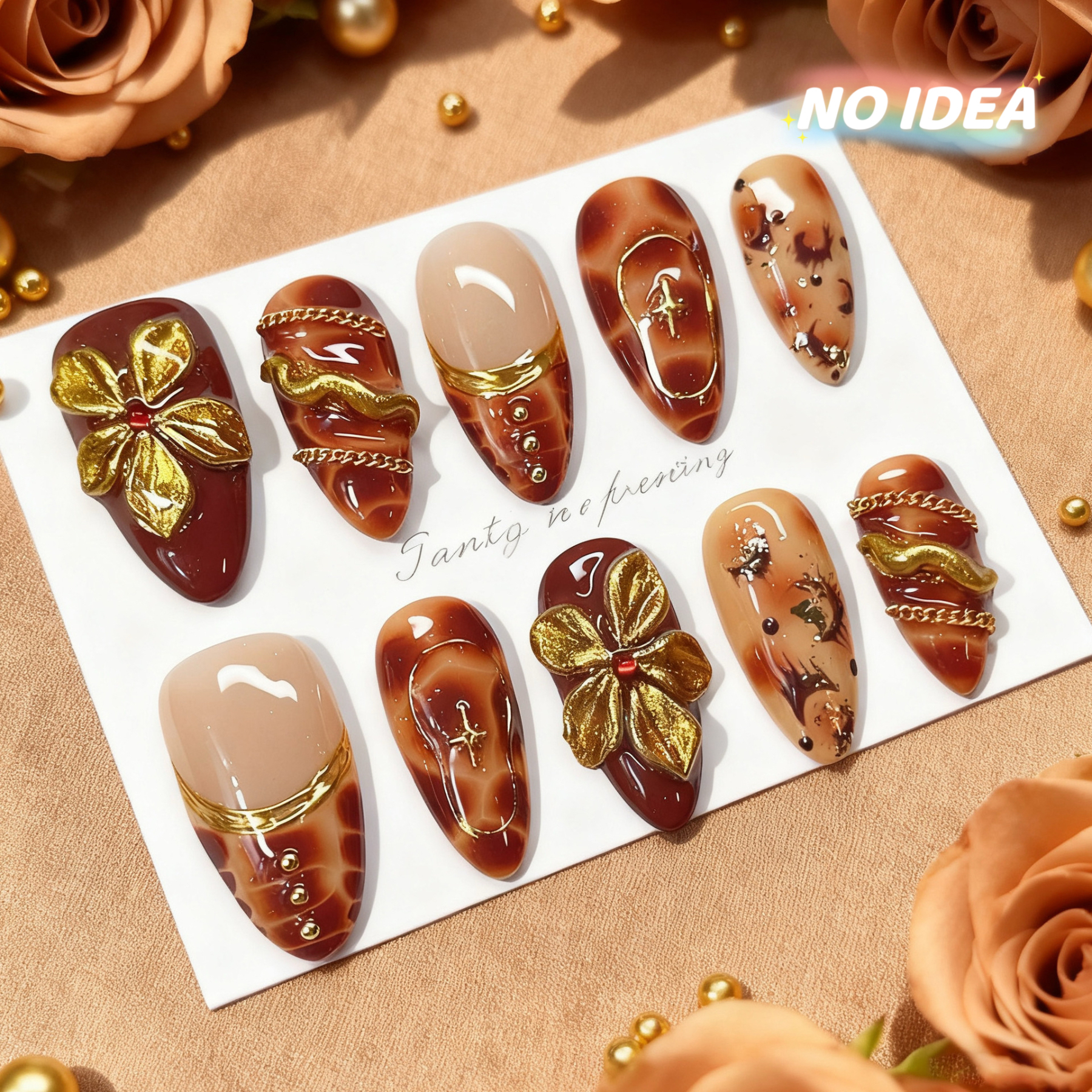 Short almond shaped press on nails in wine red with detailed gold or silver metallic floral patterns.