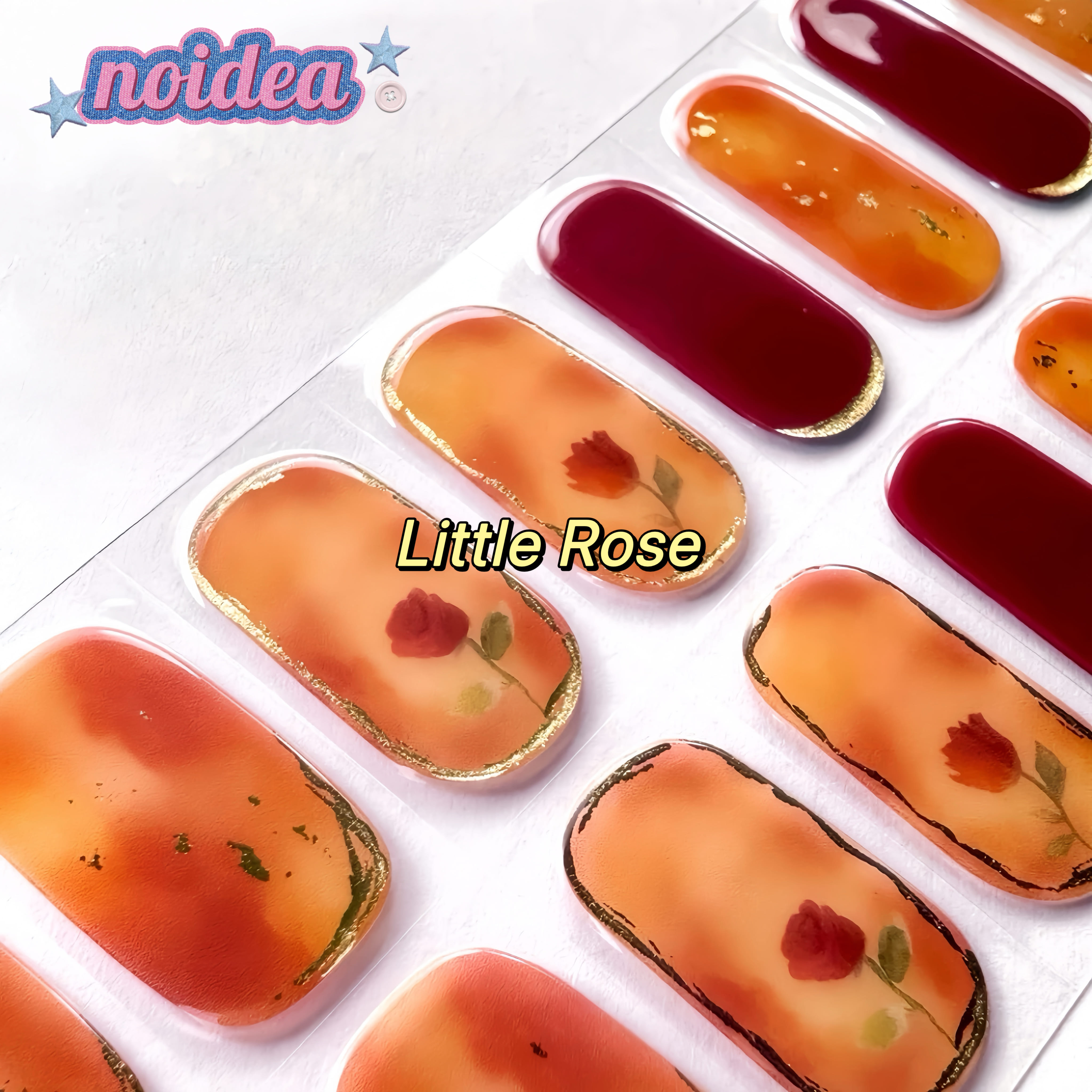 A flat lay of a sheet with 20 little roses floral gel nail stickers on red and amber base