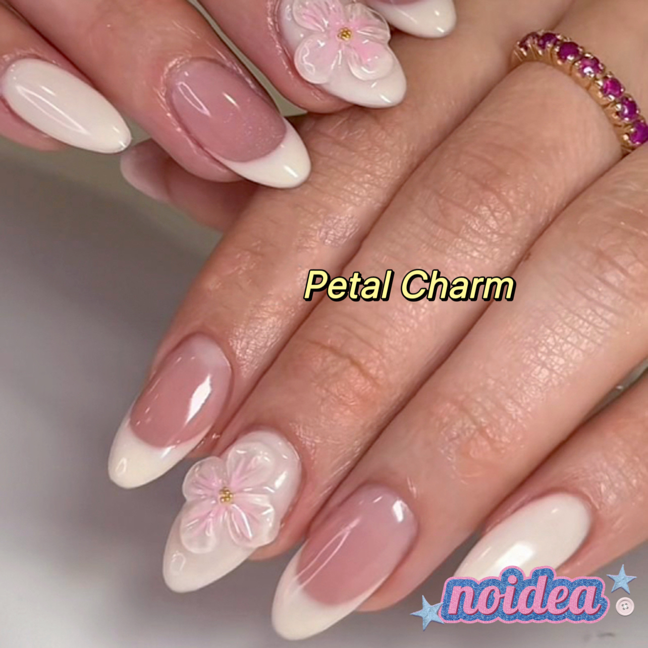 24 pieces of short almond-shaped press on nails with pink and white floral design, shown with jelly glue and tool, laid out to display 12 sizes