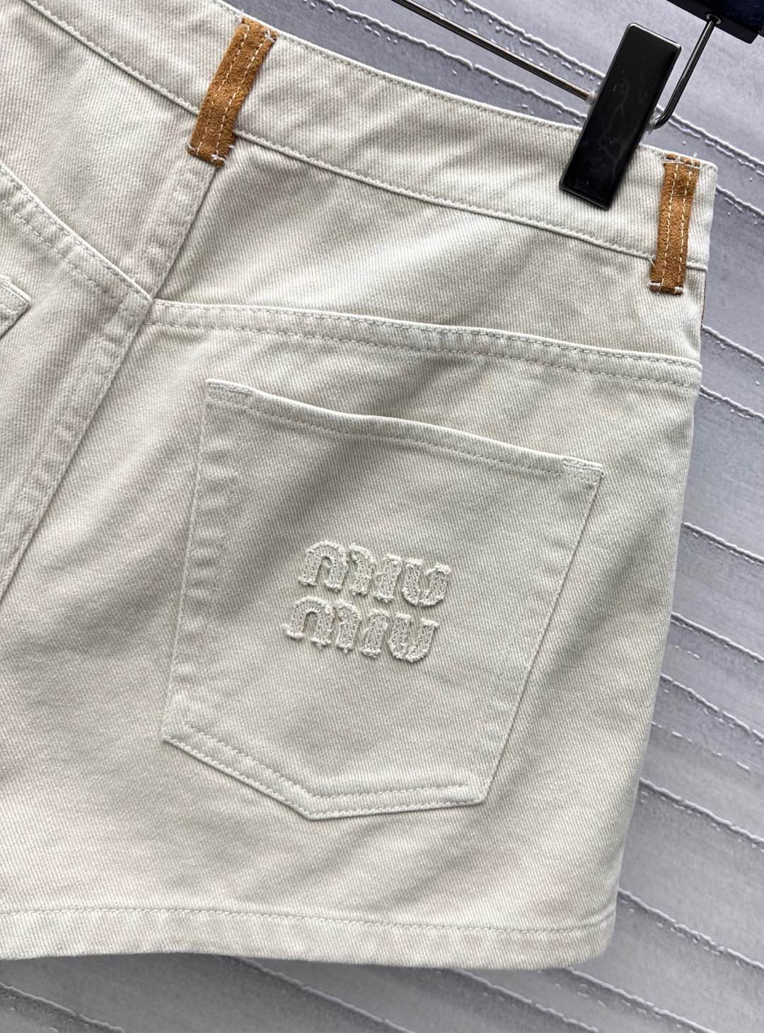 MIU25SS wrap-around patchwork denim shorts