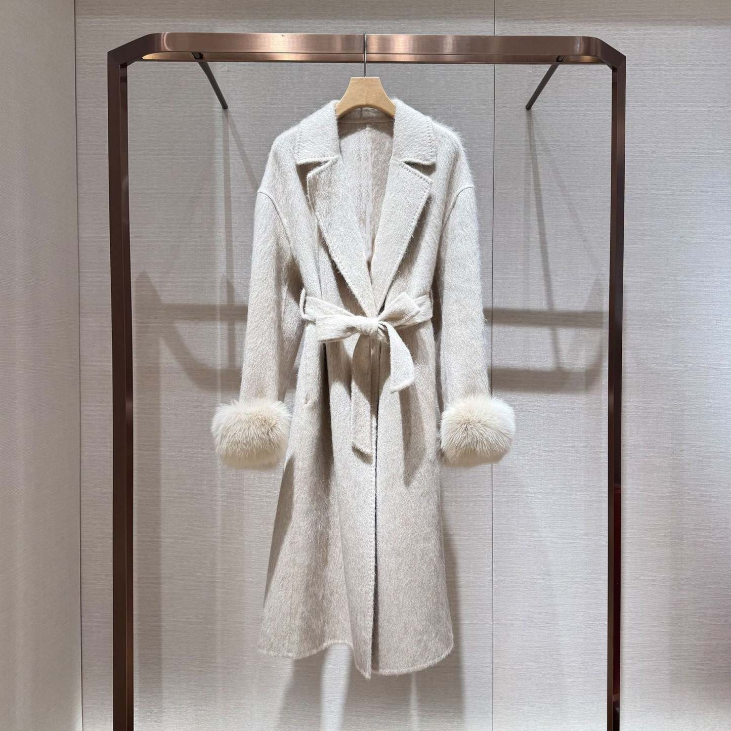 White coat with fur-trimmed sleeves, belted collar, and warm double-faced wool fabric