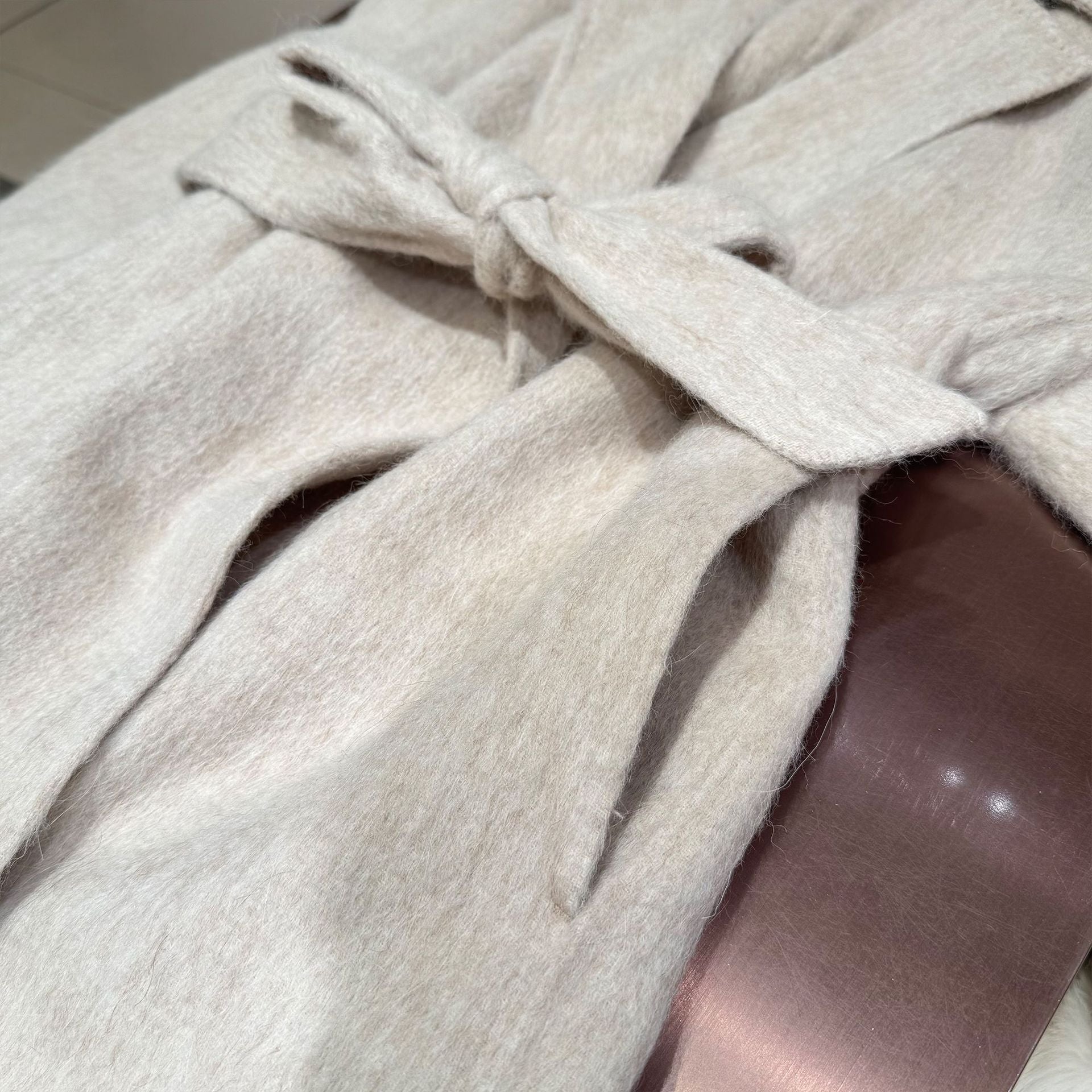 White coat with fur-trimmed sleeves, belted collar, and warm double-faced wool fabric