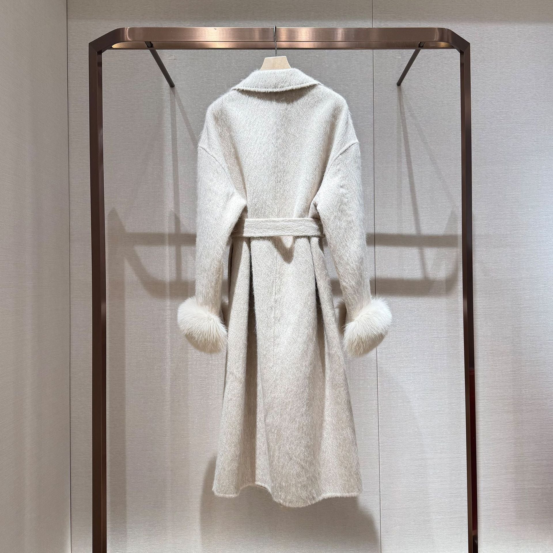 White coat with fur-trimmed sleeves, belted collar, and warm double-faced wool fabric