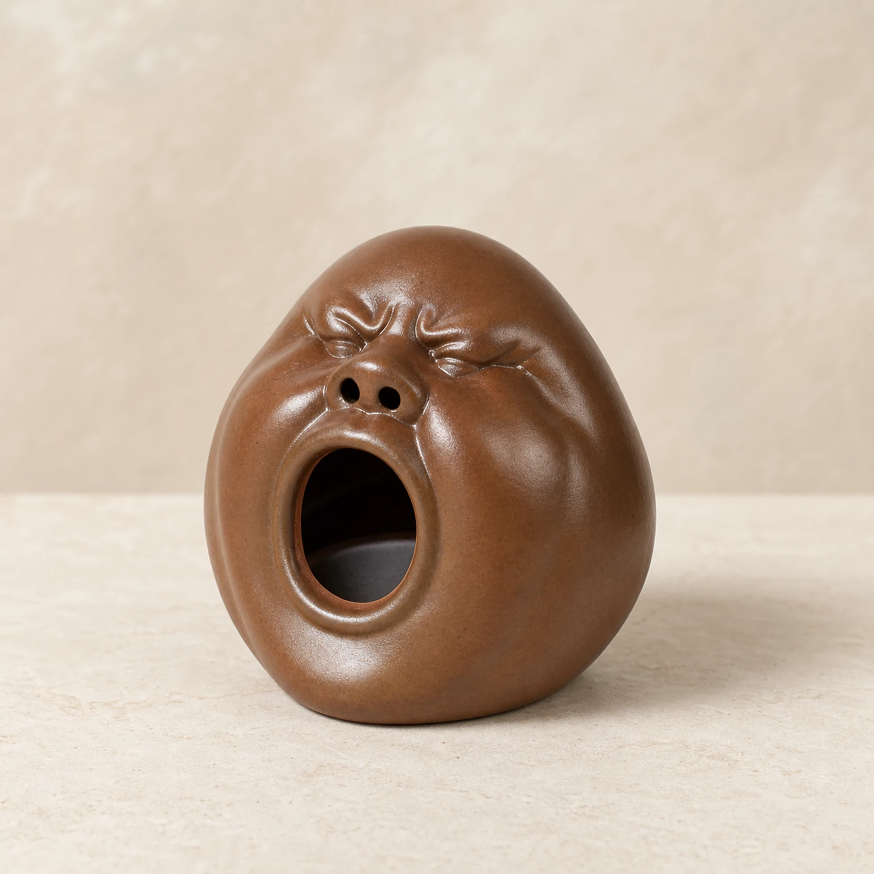 Brown expressive face incense holder clean three-quarter view
