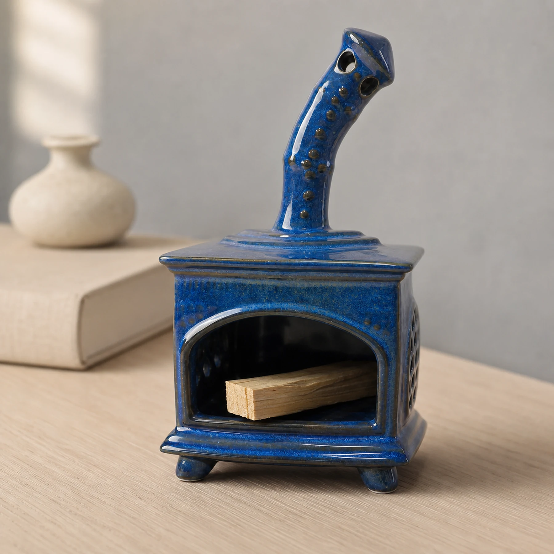 Blue ceramic fireplace incense holder with unlit Palo Santo placed in the open hearth
