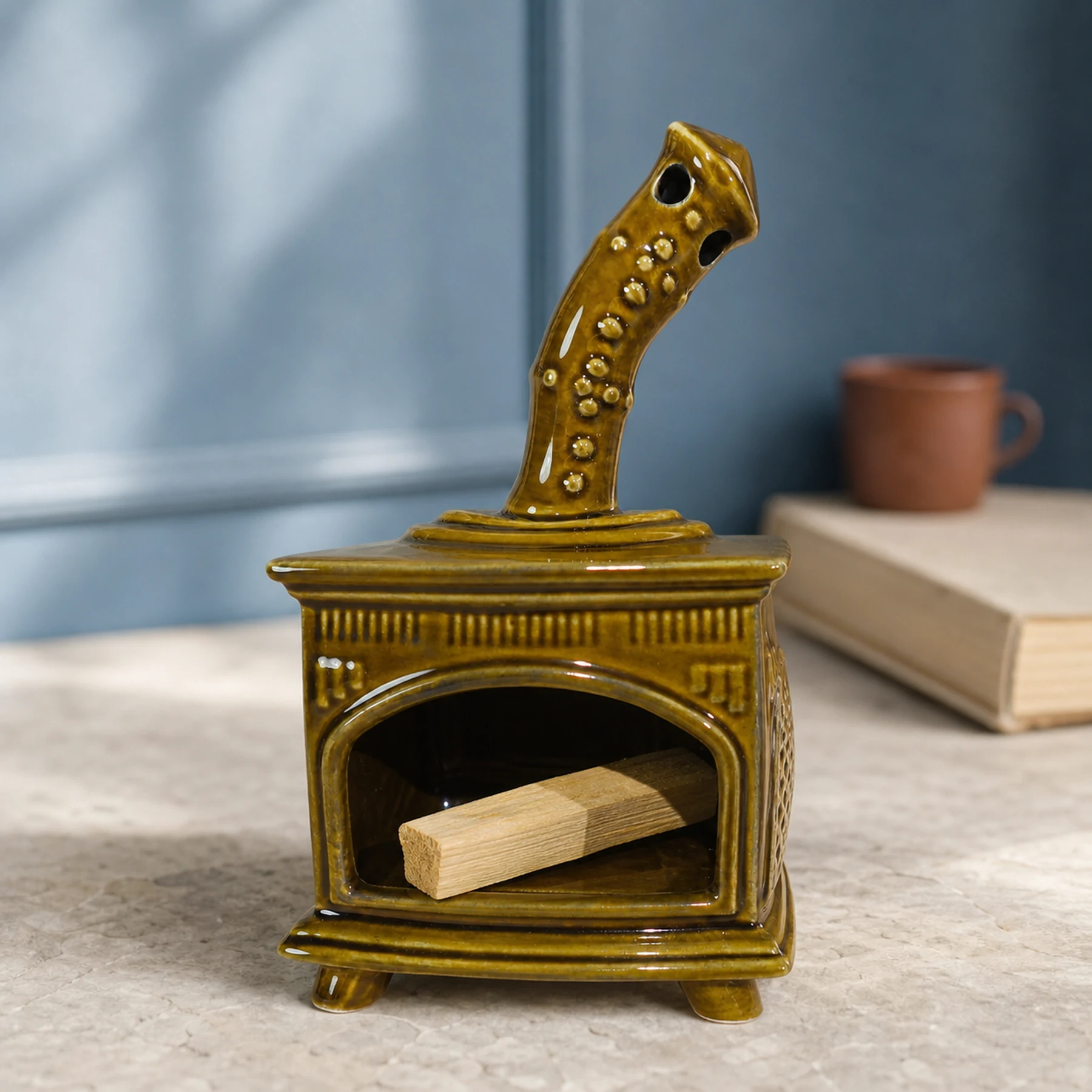Brown ceramic fireplace incense holder with unlit Palo Santo placed in the open hearth