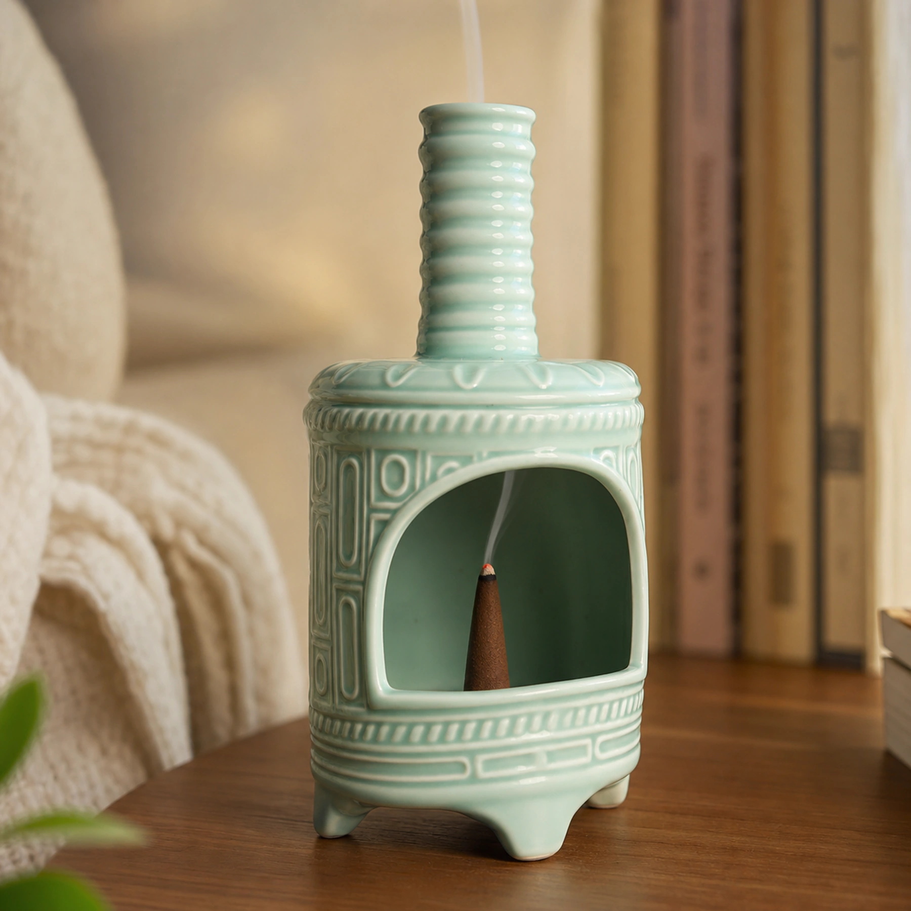 Light Green ceramic incense burner with a tapered cone ember and smoke rising through the chimney
