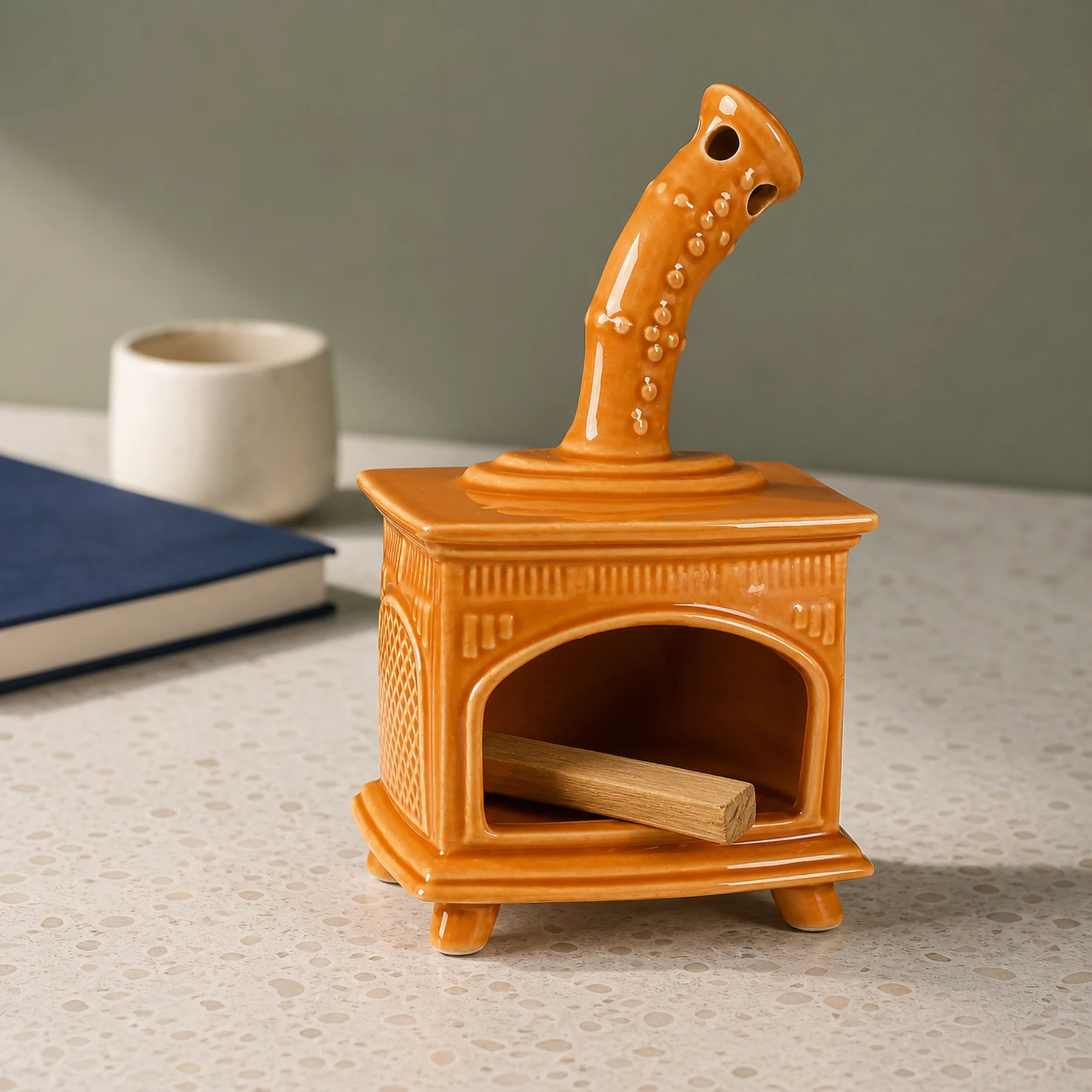 Orange ceramic fireplace incense holder with unlit Palo Santo placed in the open hearth