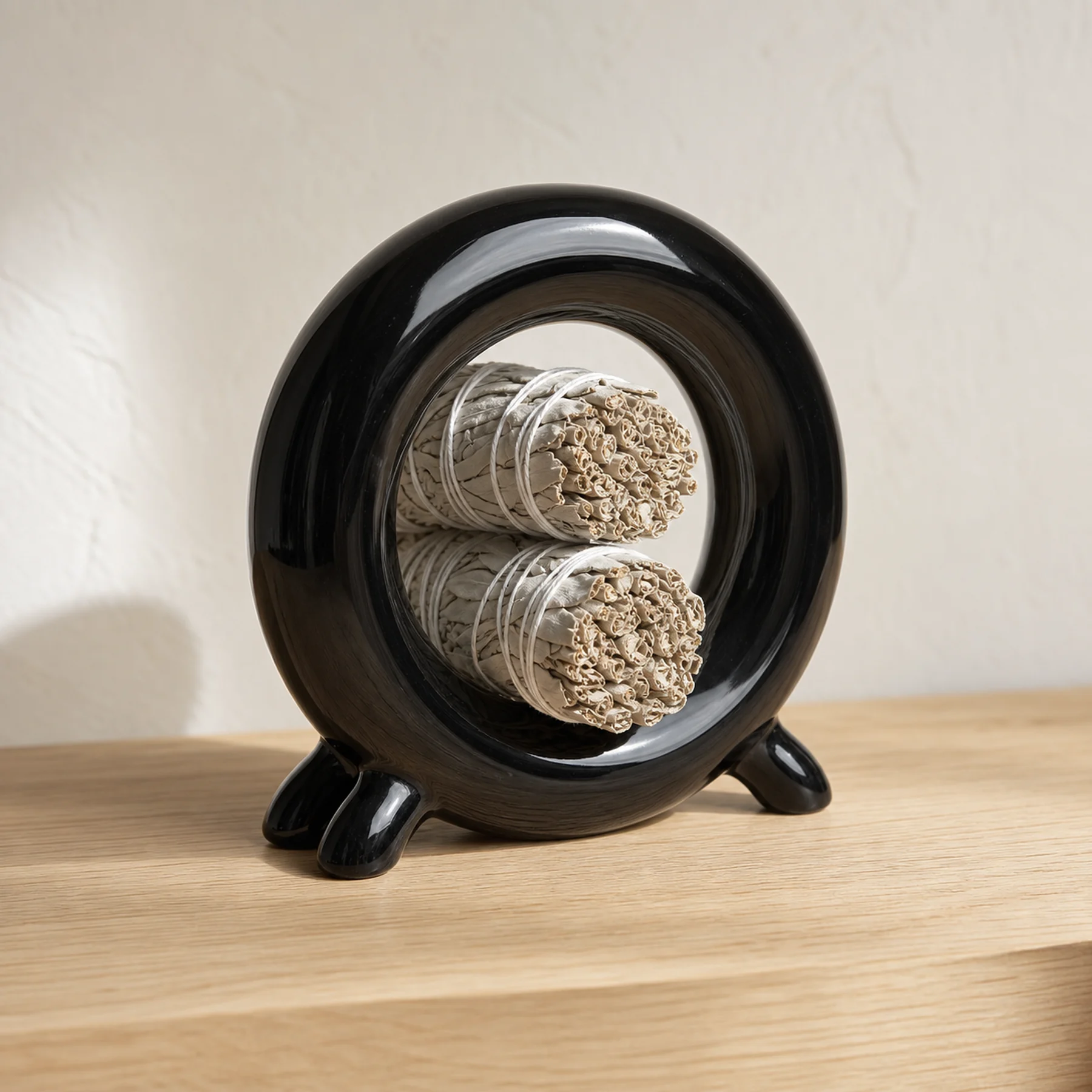 Glossy black ceramic holder storing dry unlit sage bundles