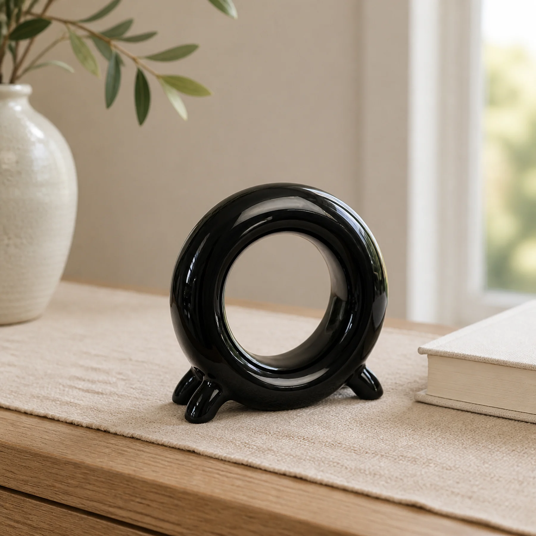 Glossy black ceramic ring storage holder styled on pale oak
