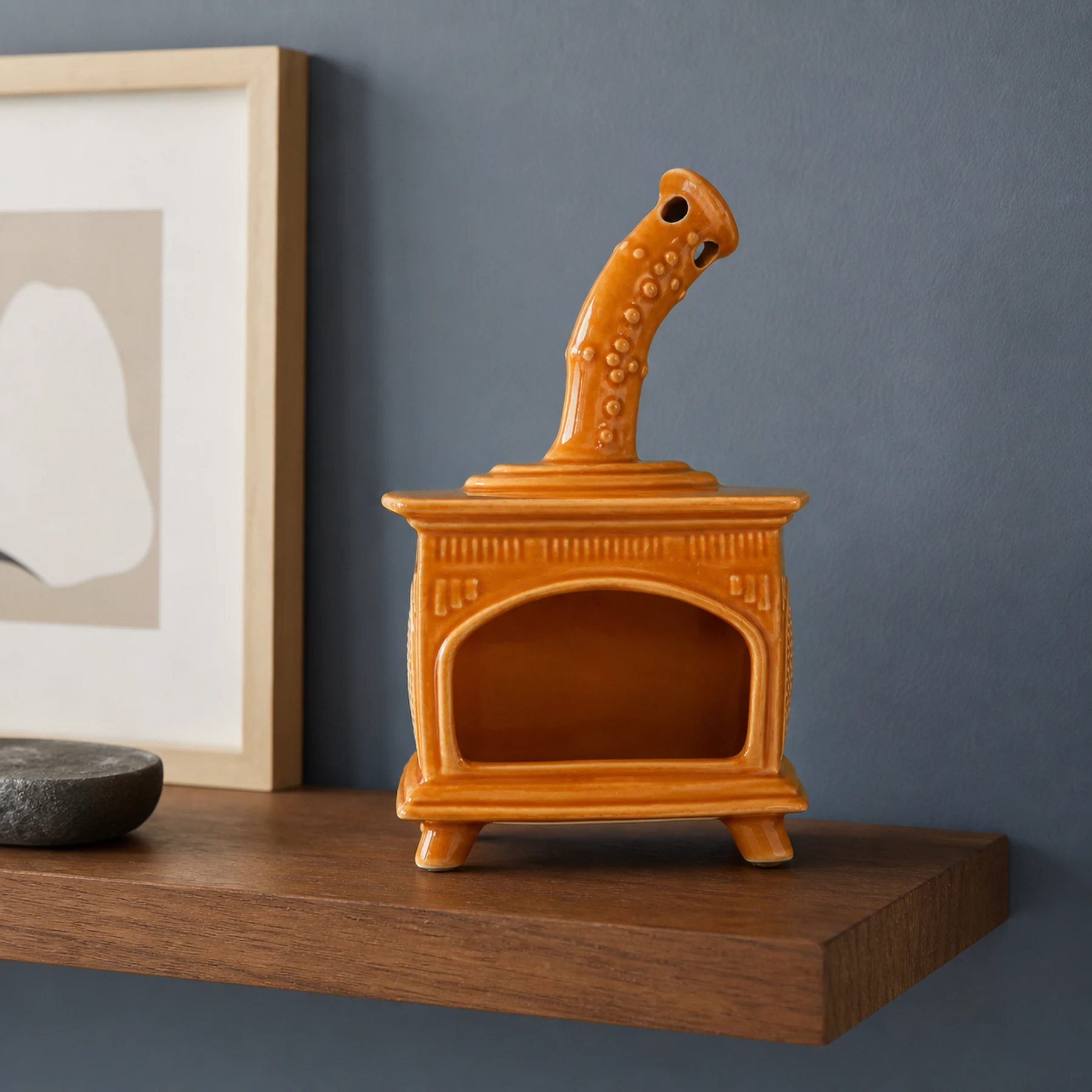 Orange ceramic fireplace incense holder styled on a home mantel shelf