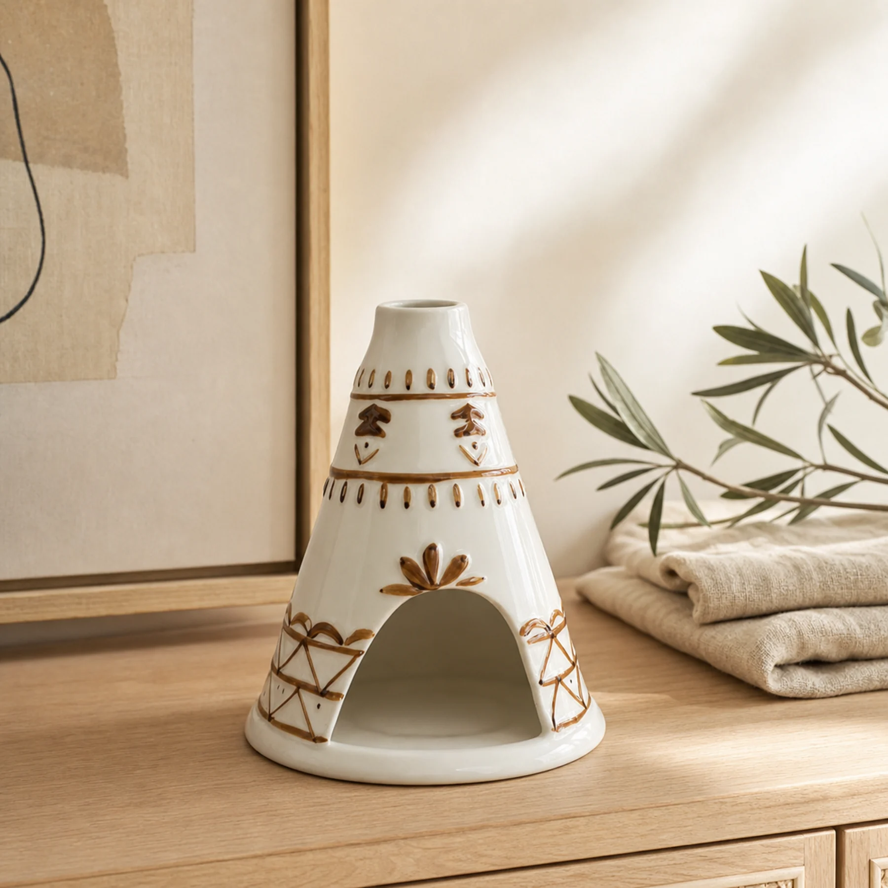 White ceramic chimney incense burner styled on a pale wood sideboard