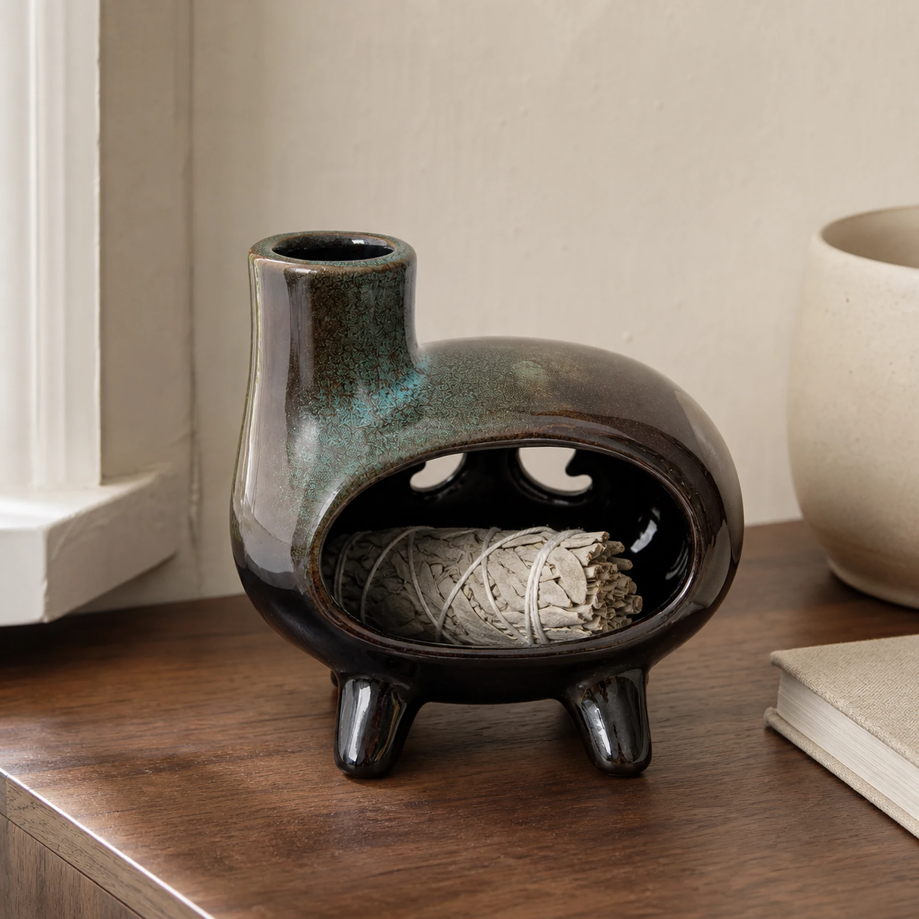 Green glaze ceramic Palo Santo holder with a small unlit sage bundle in a home setting