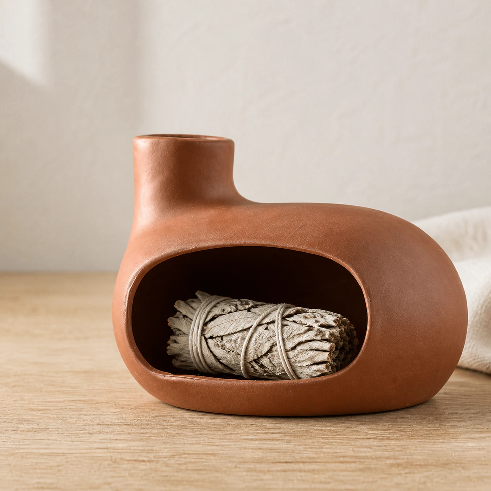 Auburn red Classic Ceramic Palo Santo & Sage Burner, home scene with an unlit white sage bundle in the front chamber.