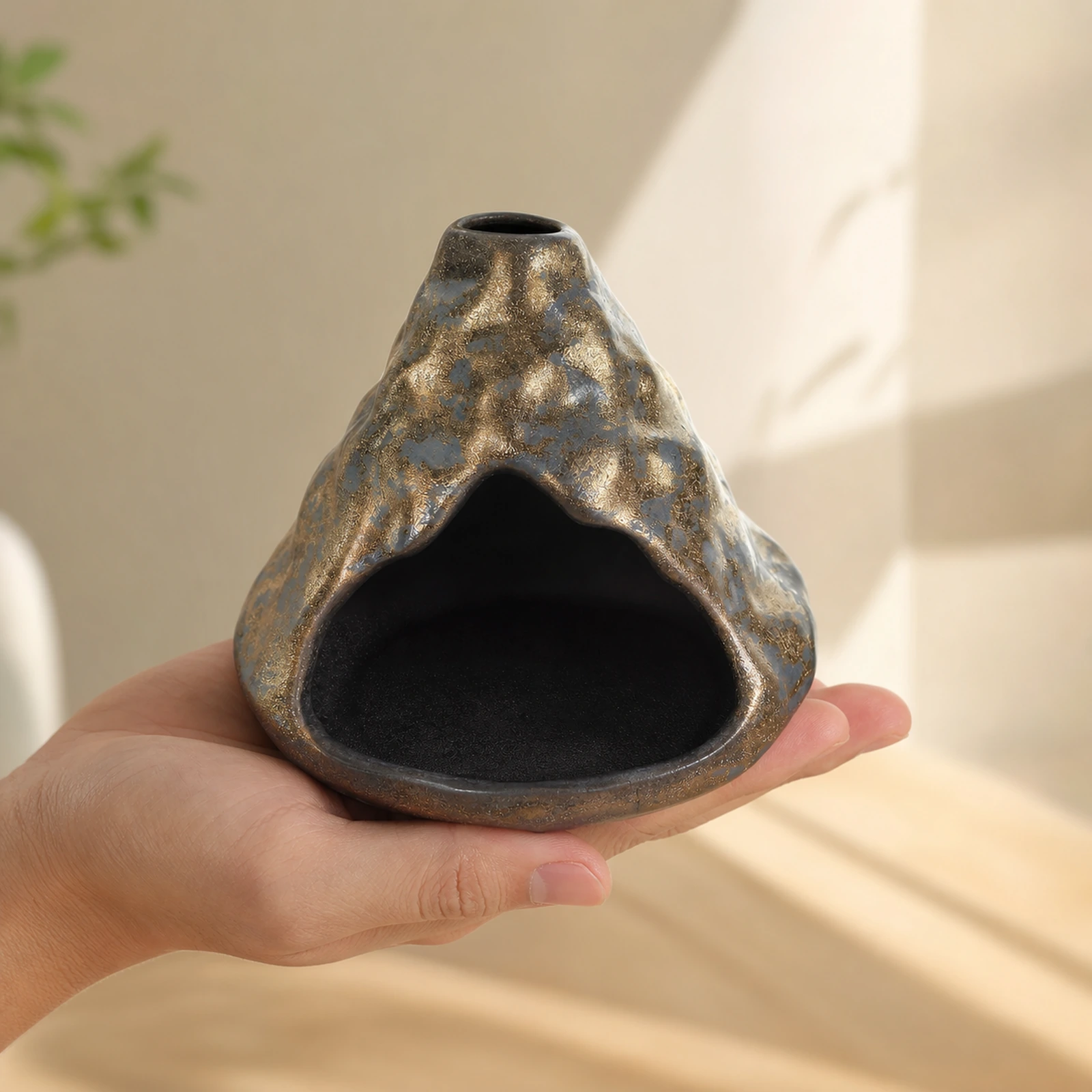 Black-Gold ceramic zongzi incense holder supported in one hand to show tabletop scale
