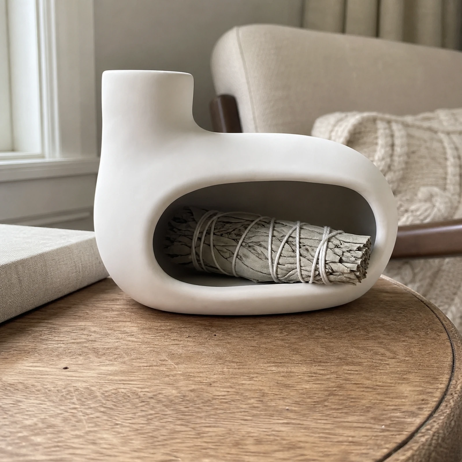Bright Moon White elongated Classic Ceramic Palo Santo & Sage Burner, home scene with an unlit white sage bundle in the front chamber.