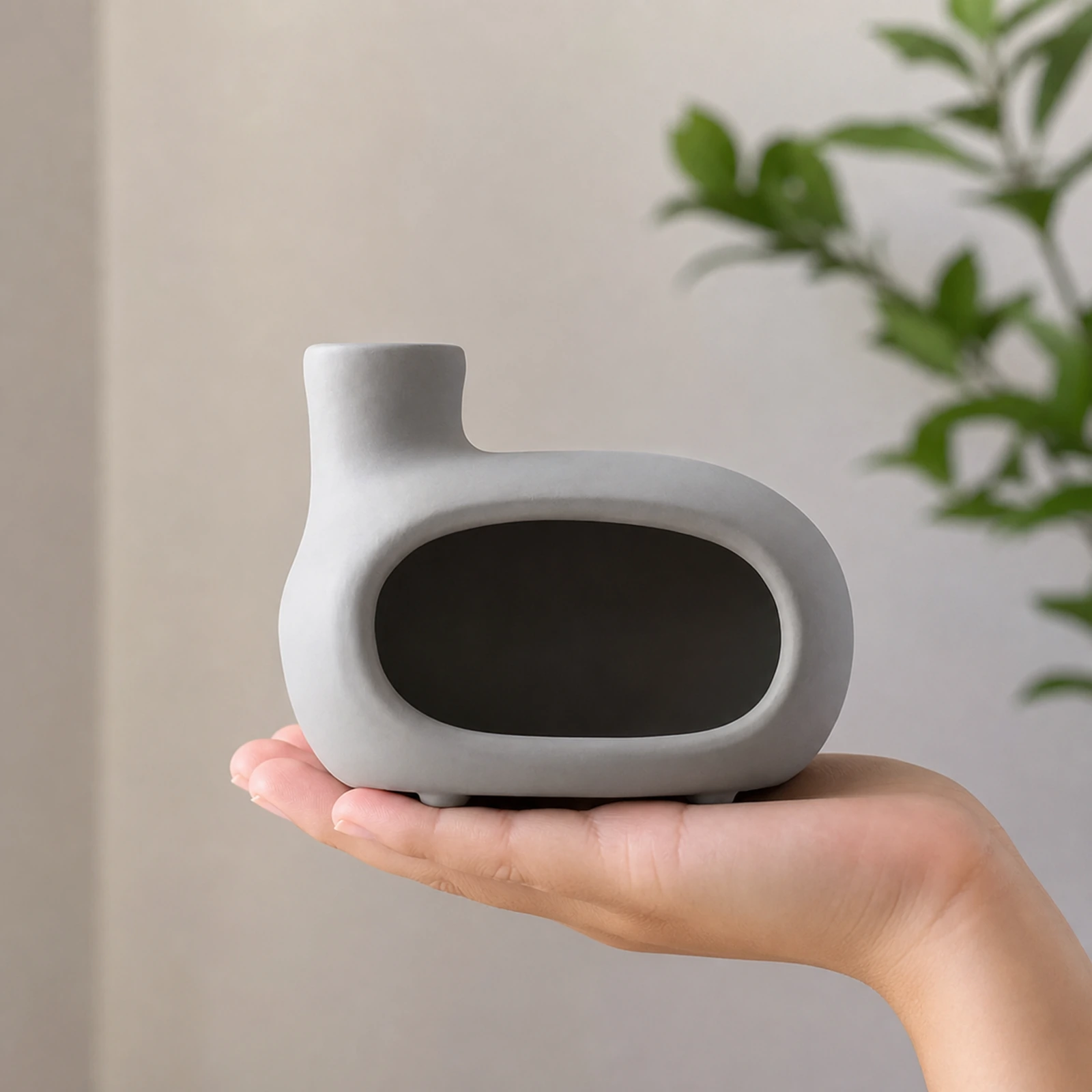 Brown gray elongated Classic Ceramic Palo Santo & Sage Burner, held in an adult hand to show approximate tabletop scale.