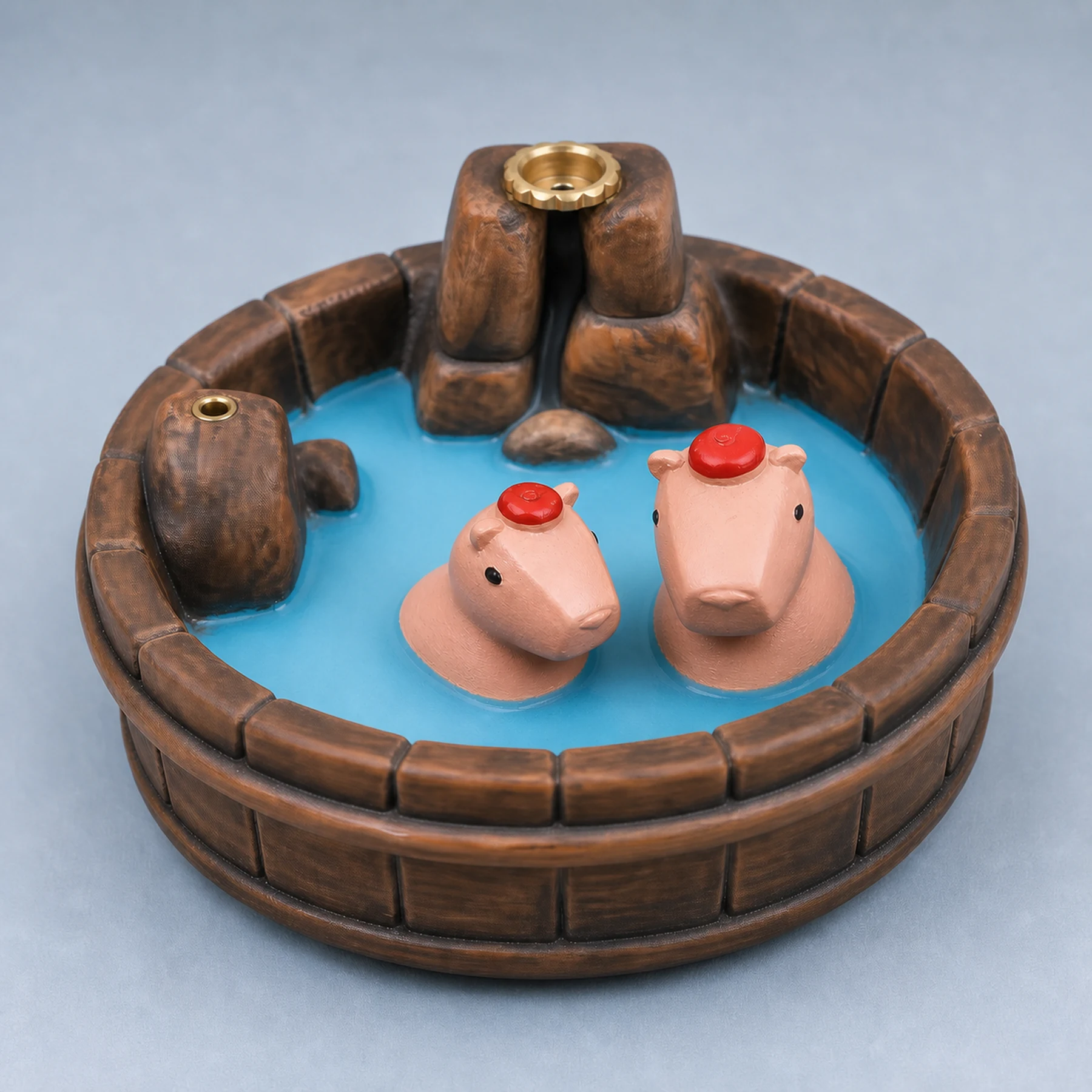 Brown wood-grain resin capybara incense burner detail showing two pink animals and brass holders