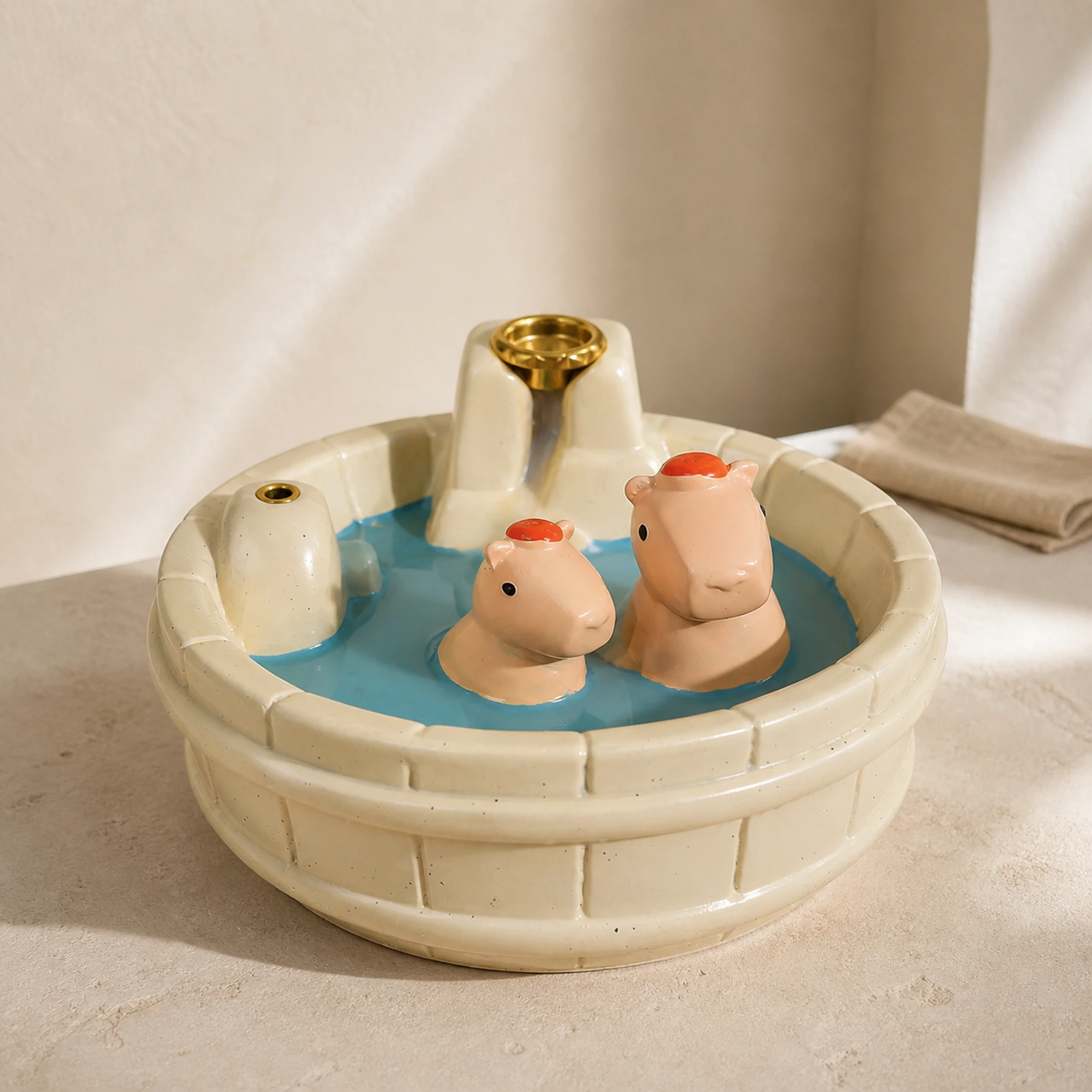 White resin capybara backflow incense burner in a clean front three-quarter view with both brass holders empty